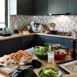 Plan de travail et ustensiles dans une cuisine en L moderne et bien équipée