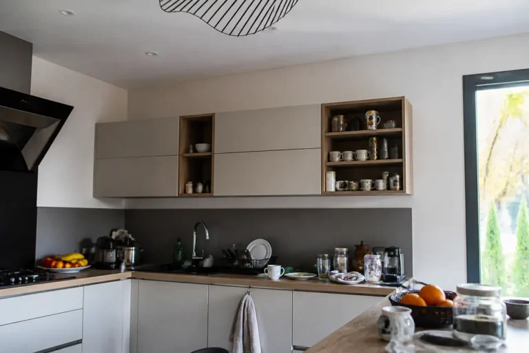 Cuisine moderne avec étagères ouvertes et fermées soulignant la hauteur des meubles hauts.